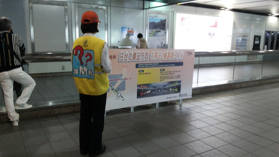 穿著黃色背心,背心後印著『請問我』的解說員,提供旅客即時解說。 (photo by 台北捷運公司)