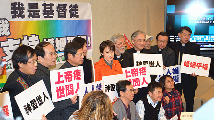 蕭美琴立委和一群牧師高舉「神愛世人」、「上帝疼世間」等標語,表達支持婚姻平權的觀點。(photo by彭書穎/台灣醒報)