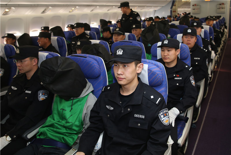 被中國在肯亞強押的45名台灣人,被戴上黑色頭套,飛抵北京。(photo by 新華社)