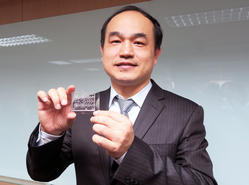 清大動力機械工程學系講座教授李國賓11日介紹研發成果,手上為檢測糖化血色素值的晶片。(photo by 林亭妤/台灣醒報)