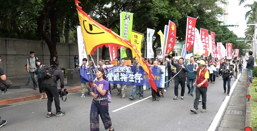 2017秋鬥12日登場,61個工運團體集結數百人扛著鐵鍊,遊行至總統府前,並朝總統府丟蔡英文競選時的「小豬」撲滿,表達強烈抗議。(photo by 洪進安影片截圖)