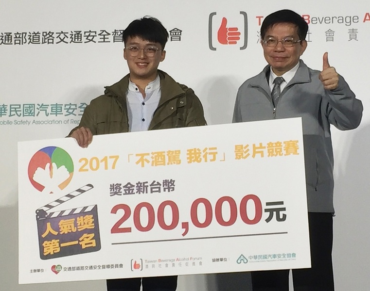 政治大學「為愛付出指定代駕」代表翁則豪(左)從交通部政務次長王國材手中接下獎狀和20萬獎金。(photo by林晏如/台灣醒報)