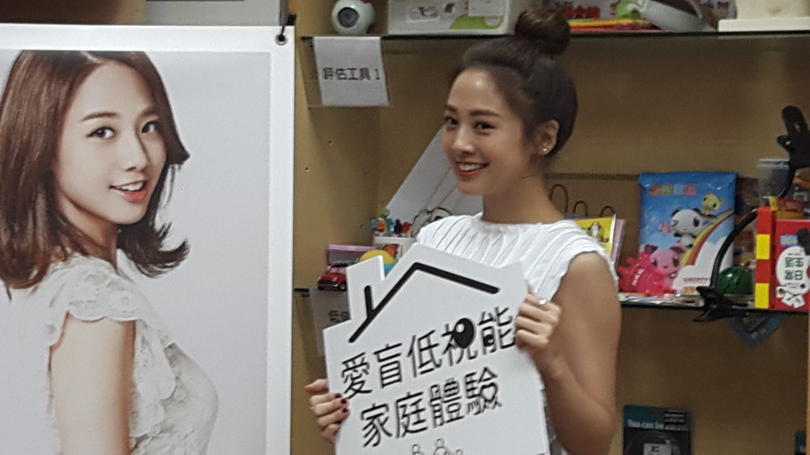鬼鬼(中)穿著白色上衣搭配格紋裙子出席愛盲基金會「低視能家庭體驗」。(photo by藍苡瑄/台灣醒報)