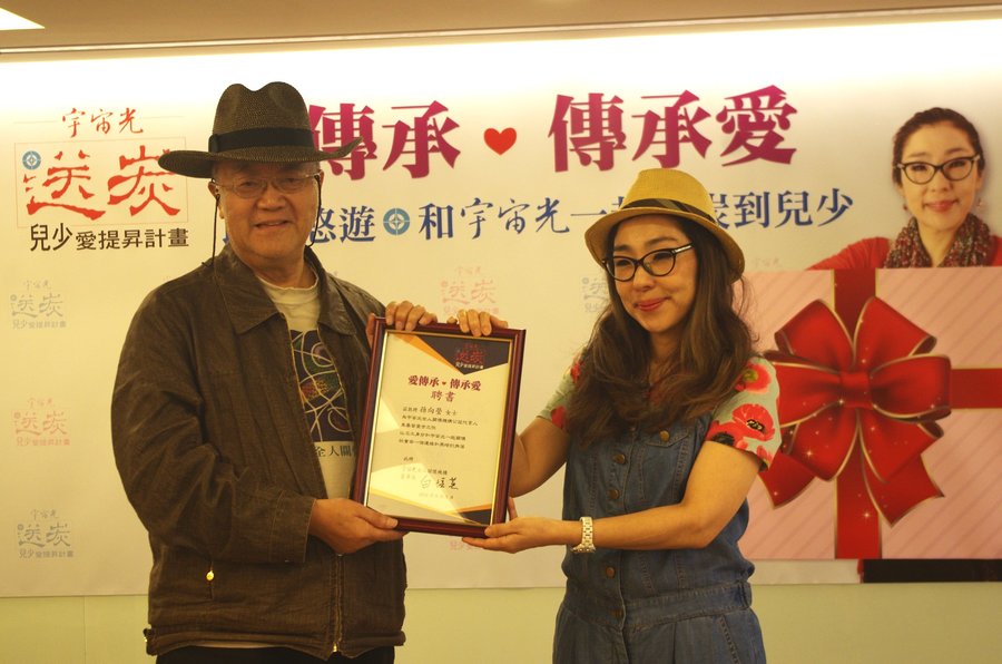 孫越女兒孫向瑩從宇宙光全人關懷機構總幹事林治平教授手中接過聘書,正式成為公益代言人。(photo by 李牧權/台灣醒報)