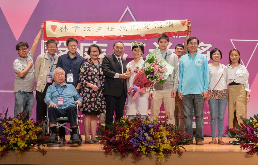 長期推動居家照護與安寧醫療的深坑區衛生所主任林幸玟(右6),從民國94年深耕至今,終獲得新北市醫療公益獎評審團與市長侯友宜(右7)的肯定,家人與衛生所同仁熱情獻花。(photo by張元融/台灣醒報)