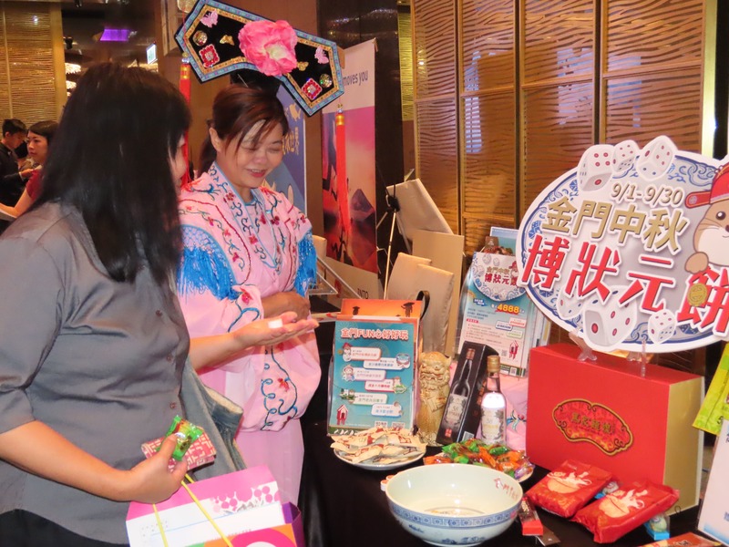 推廣金門狀元餅的攤販與民眾玩擲骰子遊戲,能贏走禮盒等優惠。(photo by 施凱文/台灣醒報)