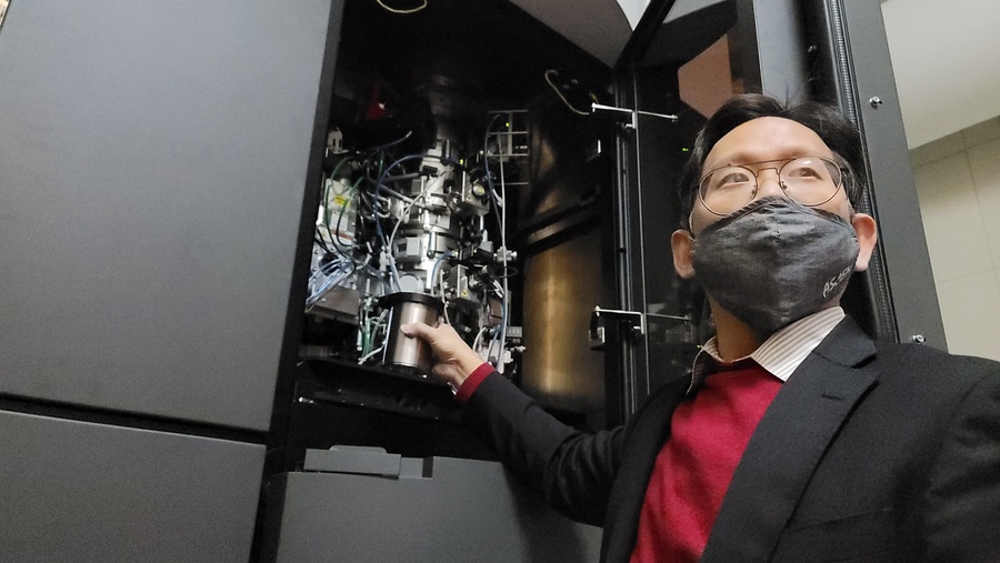 中研院生化所副研究員何孟樵將DNA樣本放入中央研究院冷凍電子顯微鏡設施(ASCEM)進行觀察示範。(photo by 祝潤霖/台灣醒報)
